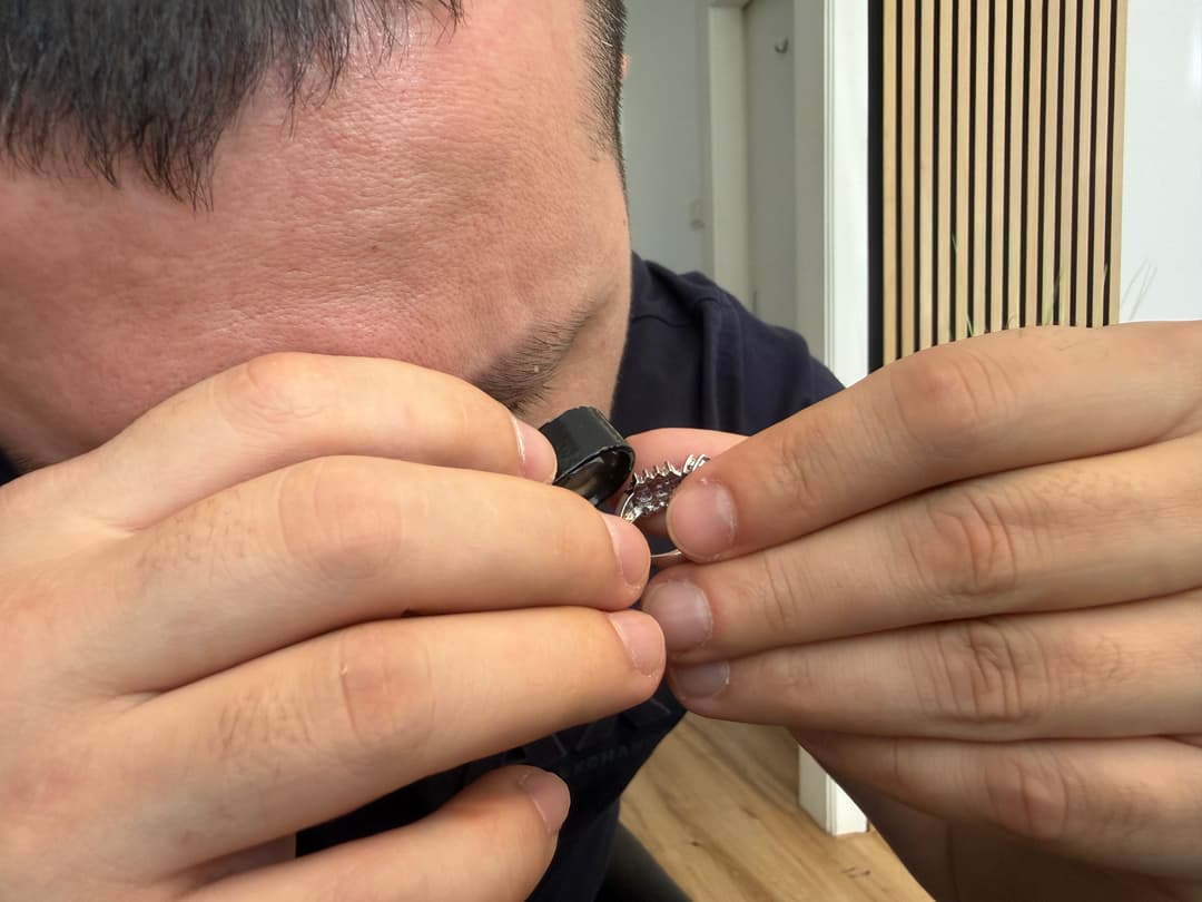 Experte prüft Erbschmuck mit professioneller Lupe bei Karat Direkt